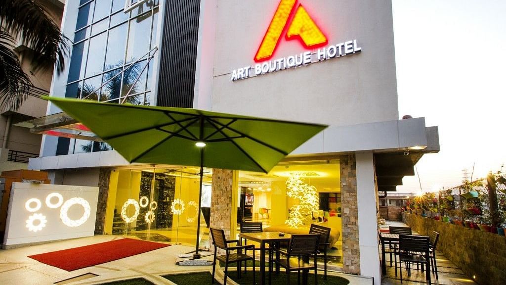 Exterior view of  Art Boutique Hotel, Hyderabad, with a sitting area outisde cover with an umbrella