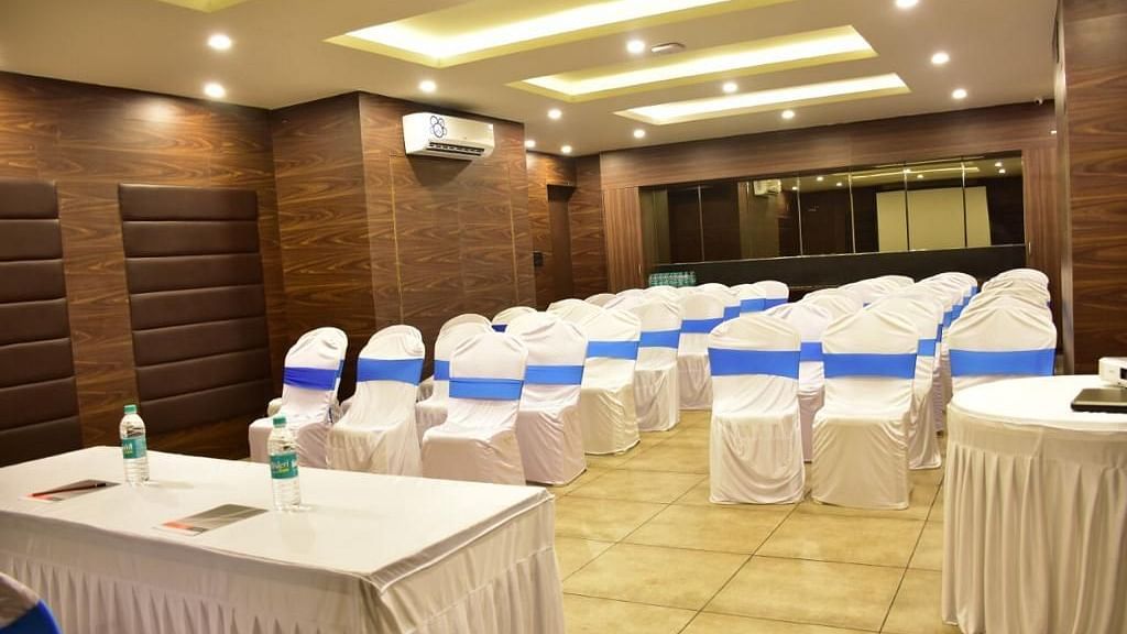 Image of a banquet hall with chairs neatly arranged and a table in front at Calux Grand Baga.