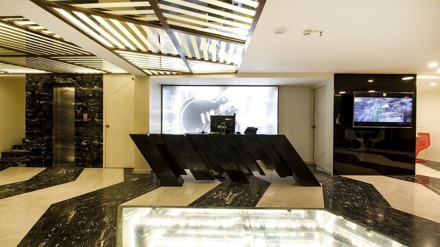Reception area witha counter table and televion on the wall at Art Boutique Hotel, Hyderabad 