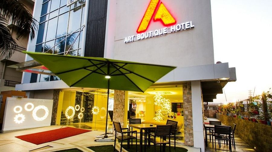 Exterior view of  Art Boutique Hotel, Hyderabad, with a sitting area outisde cover with an umbrella