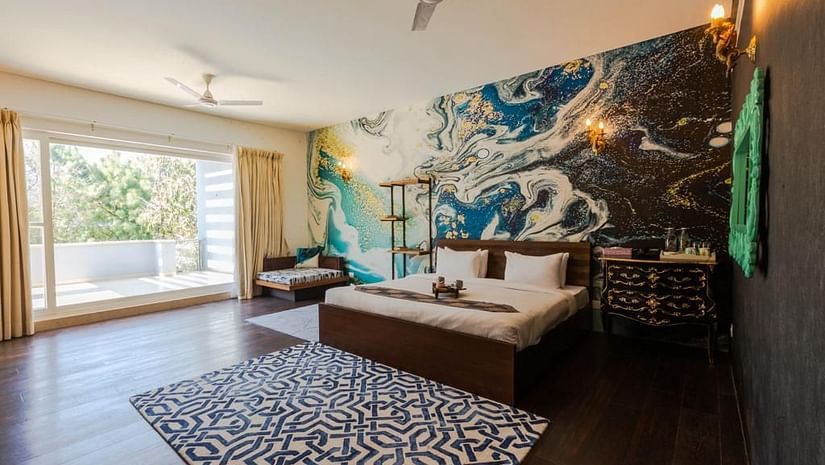 A double bed with a large painting above the bed inside Pinewood Villa - Karma Lakelands.