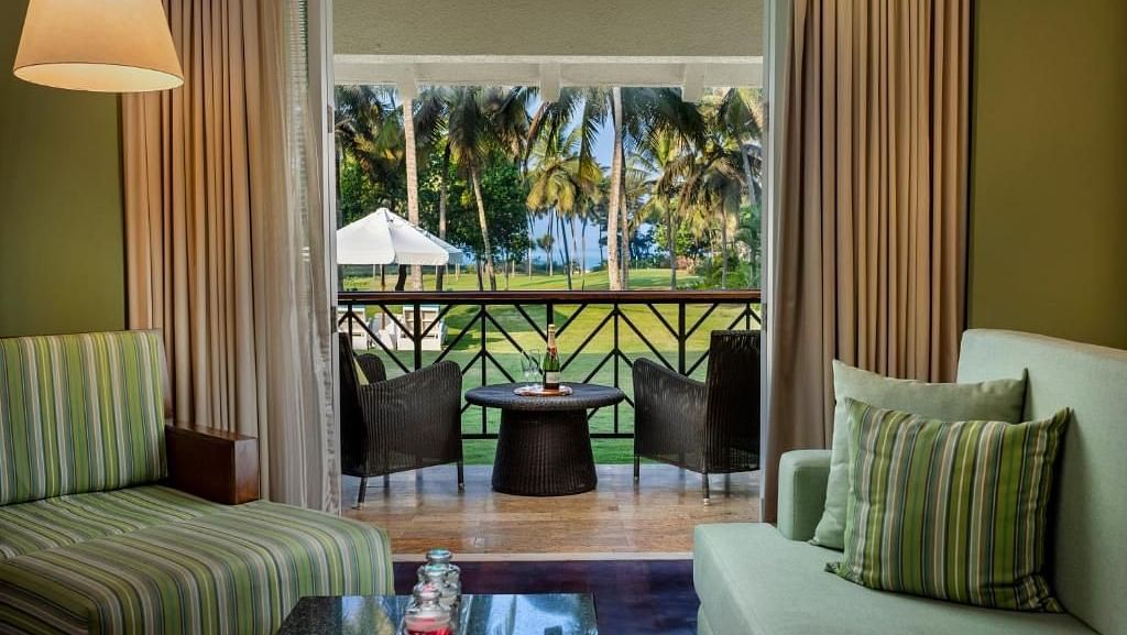 overview of the living room with sofas and a table inside one of the rooms - Caravela Beach Resort Goa