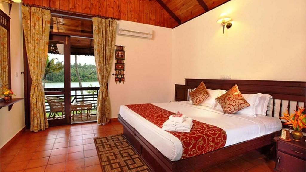  Spacious bed with decorative blankets, flanked by two bedside tables with lamps, and a large window to the side