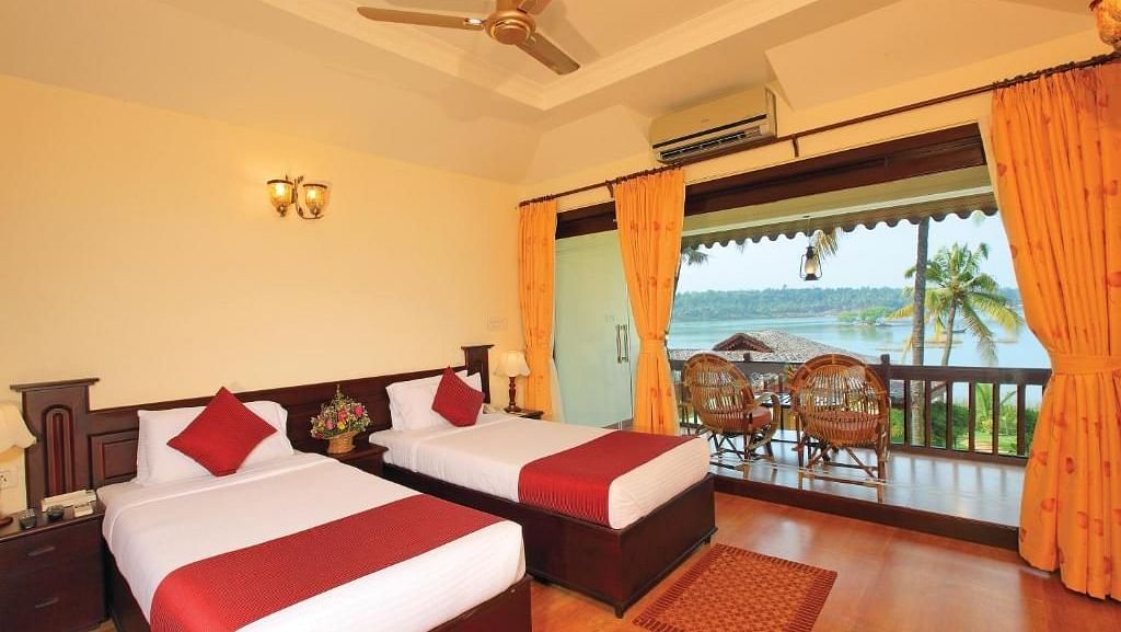 Twin bed with a stunning beach view and chairs set up to enjoy it