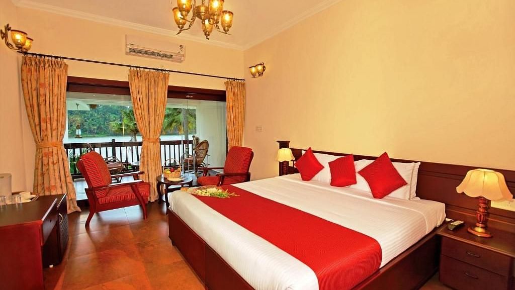  Spacious bed with decorative blankets, flanked by two bedside tables with lamps, and a large window to the side