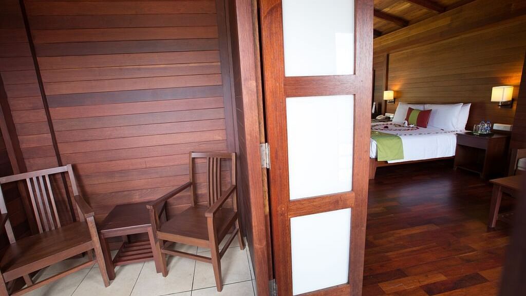 An image of a room showcasing the balcony with chairs and a small table - GReaT Trails Kodaikanal By GRT Hotels