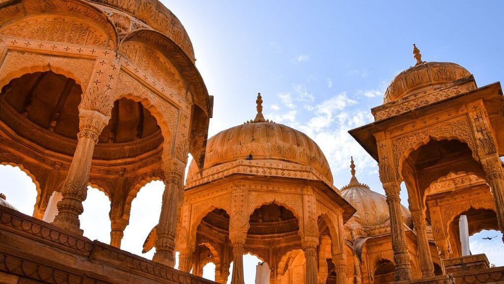 A low angle shot of the structure of a palace with a clear blue sky in the background