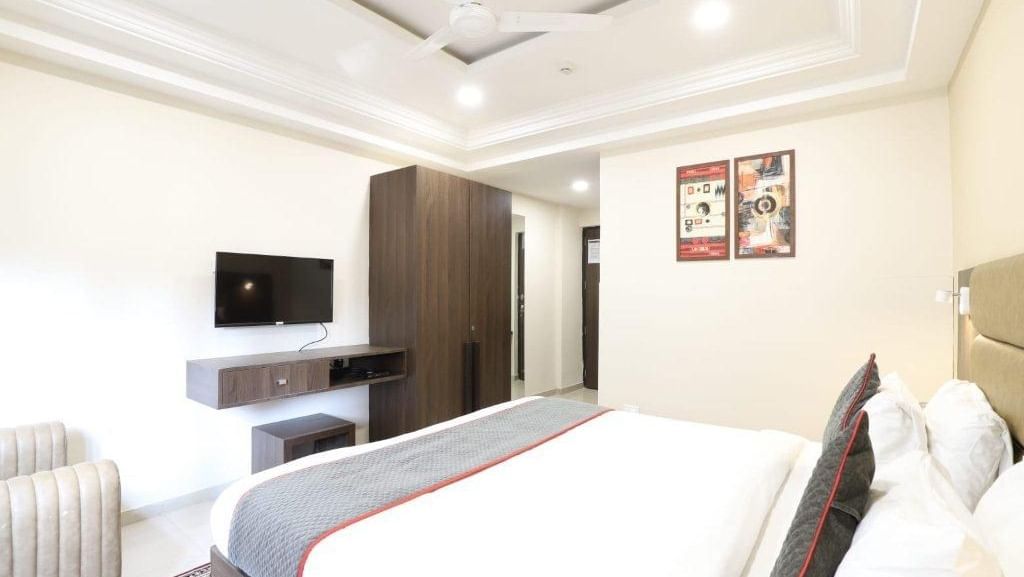 Corner view shot of the Premium Room featuring a double bed with a grey bed runner spread over it at Pravasa Ahmedabad.