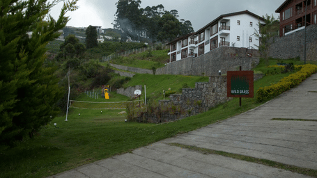 Exterior view of the property with a trail leading to the hotel surrounded by lush greenery and an amphitheatre on the side - GReaT Trails Kodaikanal By GRT Hotels