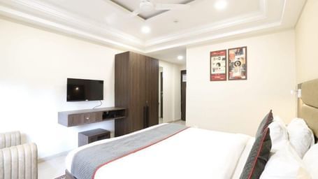 Corner view shot of the Premium Room featuring a double bed with a grey bed runner spread over it at Pravasa Ahmedabad.