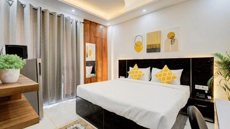 Stylish king room with contemporary furnishings at Turmeric Stays by Lime Tree Hotel, Greater Noida.