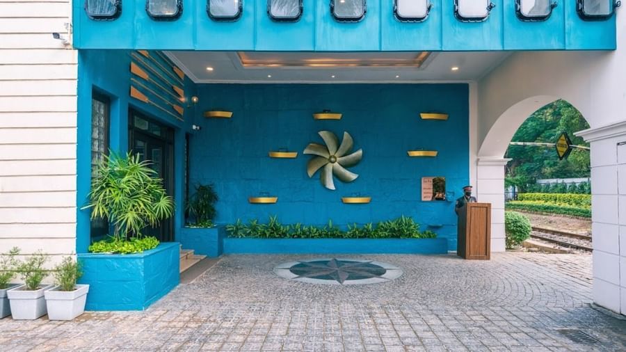 Another angle of the hotel's entrance during the day with a focus on the blue facade and the nautical-themed propeller decoration.