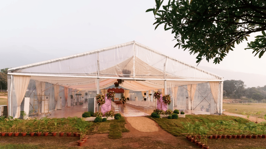 An event space Aura at Avana Resorts, featuring chairs, tables, plants, and plants set up for an event.