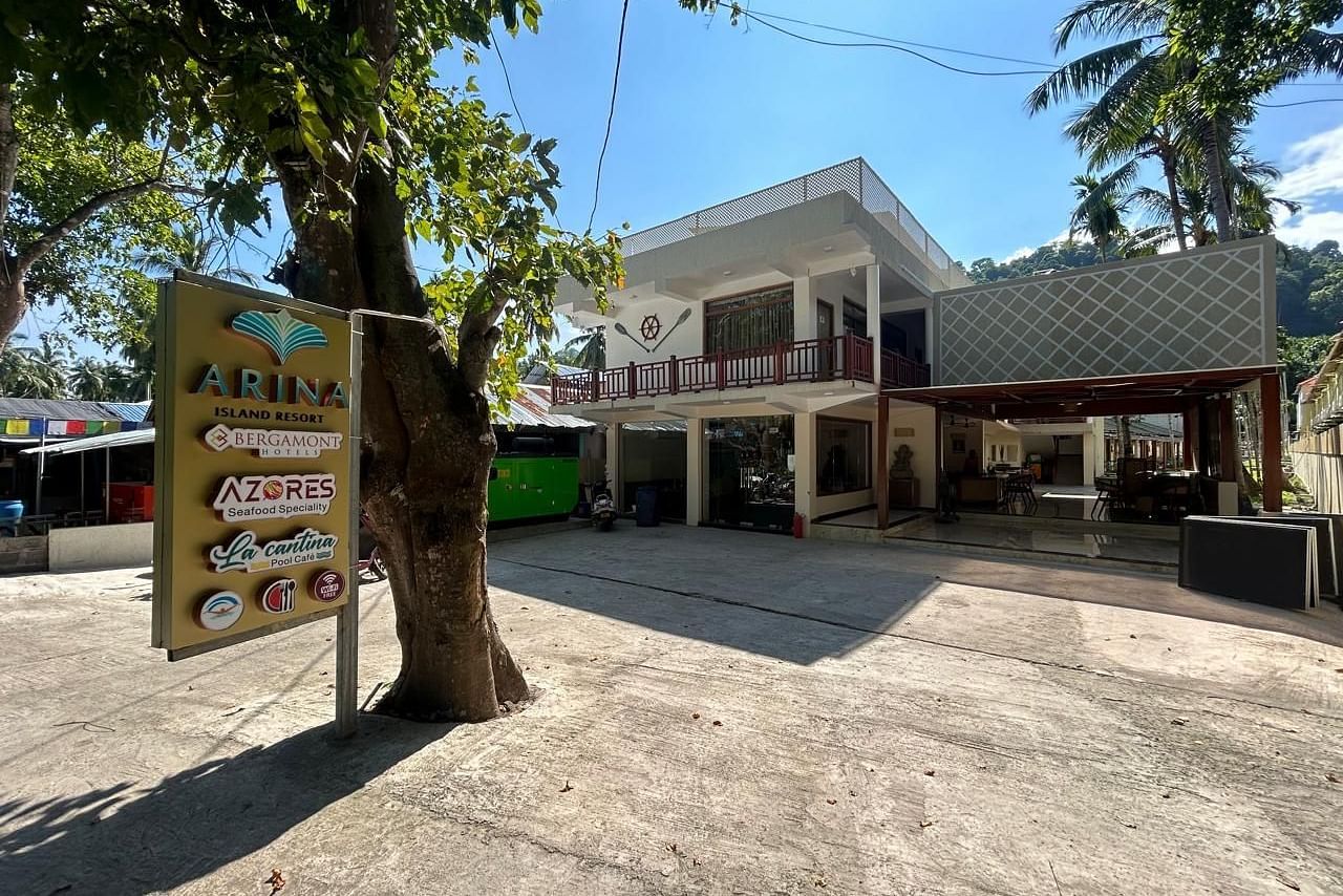 Image of the front yard at the resort during a sunny day featuring the facade  and trees all around | Arina Island Resort