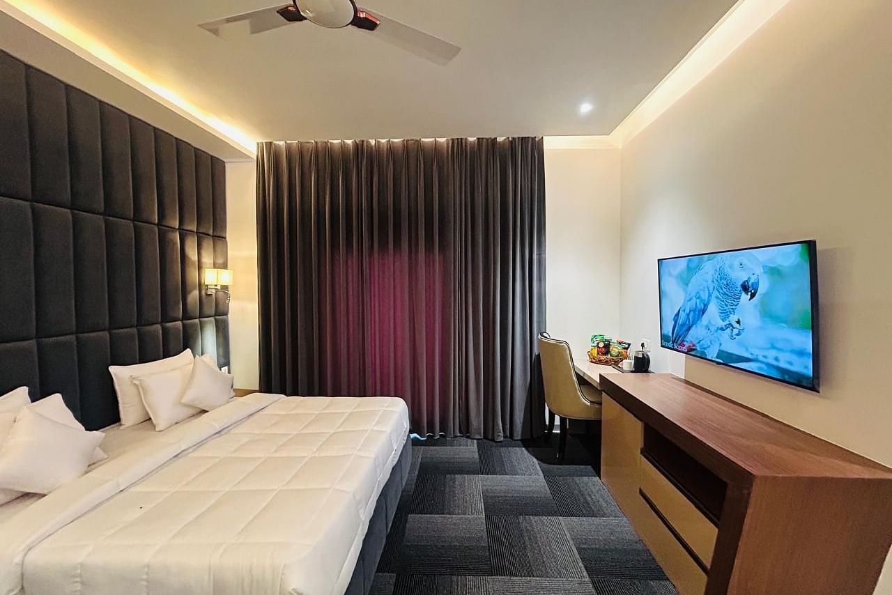 full view image of the executive room with a plush double bed and a wall mounted television at Eminence The Corbett