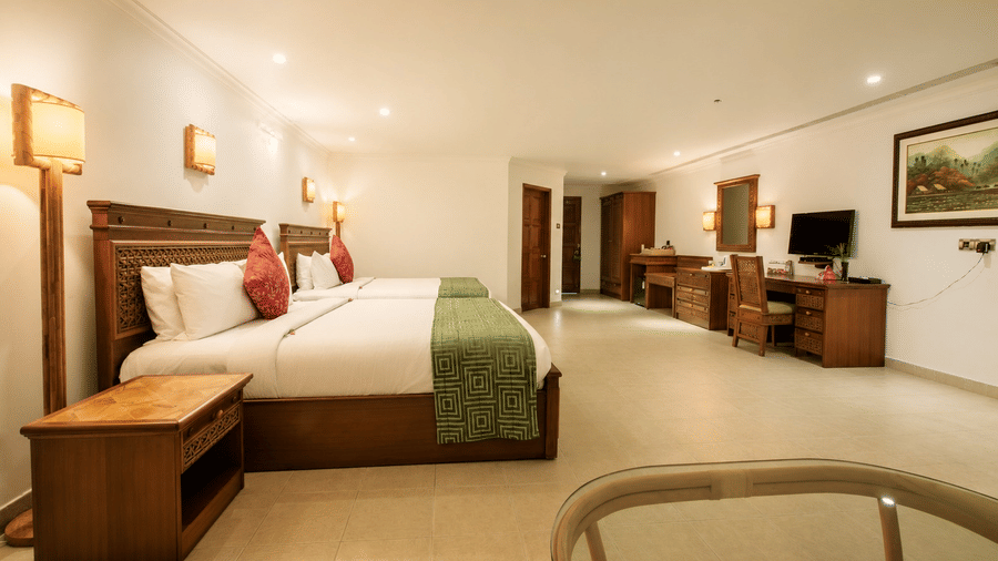 Family Room with a king bed, green accents, and an in-room jacuzzi tub at Chariot Beach Resorts, offering a spacious and relaxing stay.