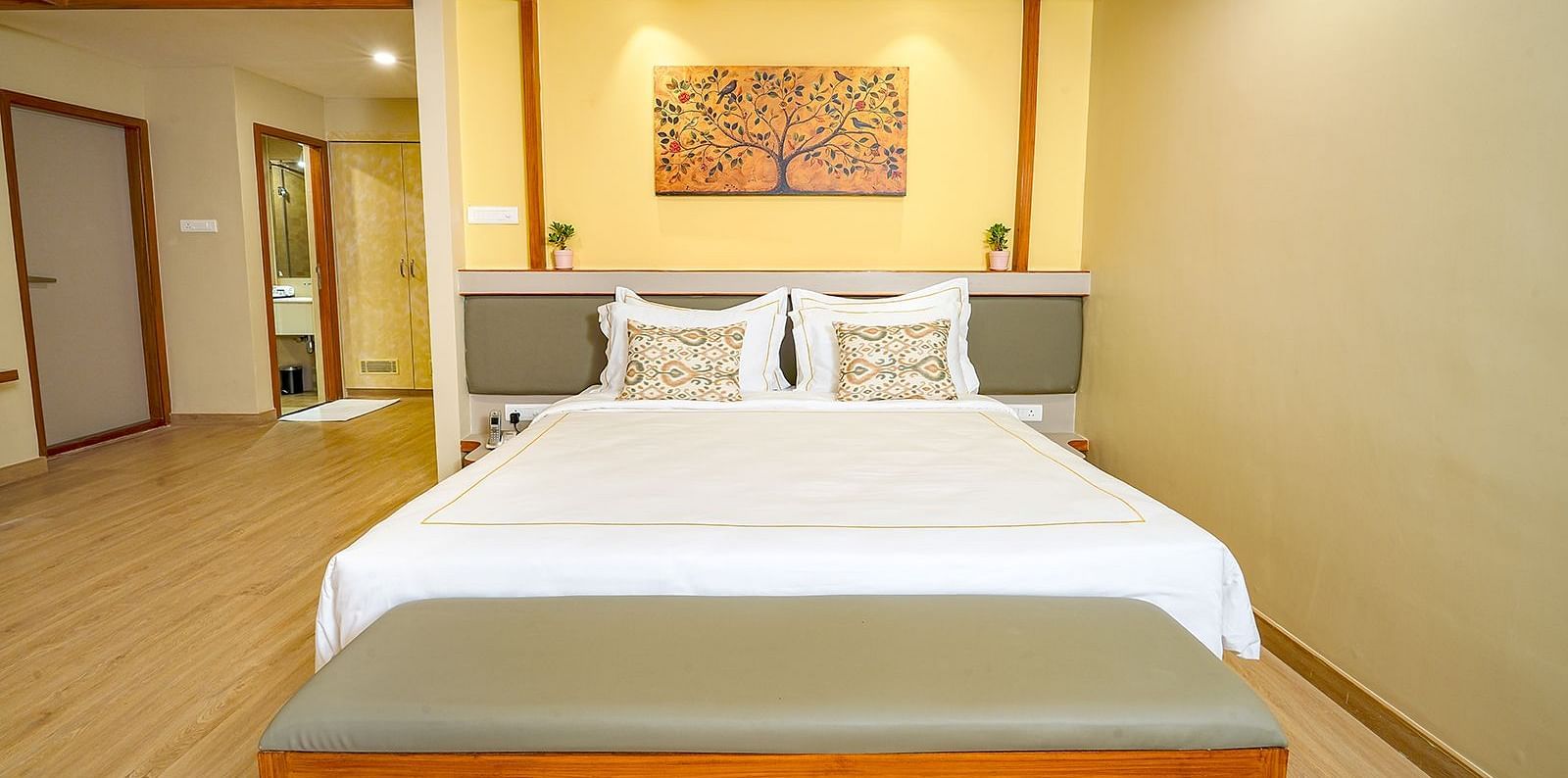Spacious king-size bedroom at Vasundhara Villa, Ramoji Film City with warm lighting and elegant décor.