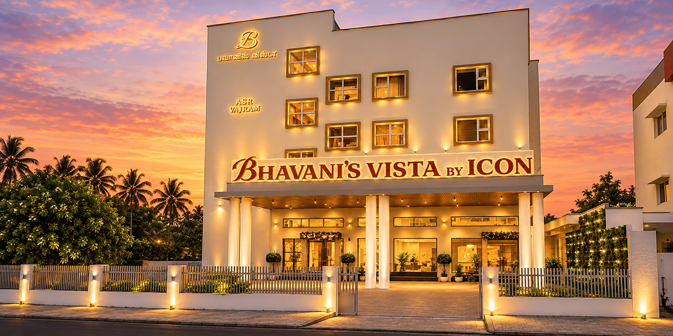 Exterior view of illuminated hotel facade at dusk at Bhavani's Vista By Icon, Hosur.   