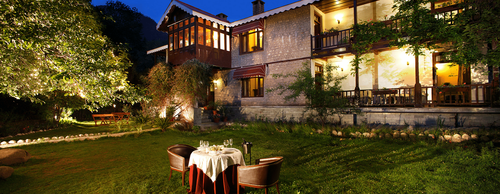 a facade of Bedzzz Xclusiv Baikunth, Manali with outdoor seating during evening