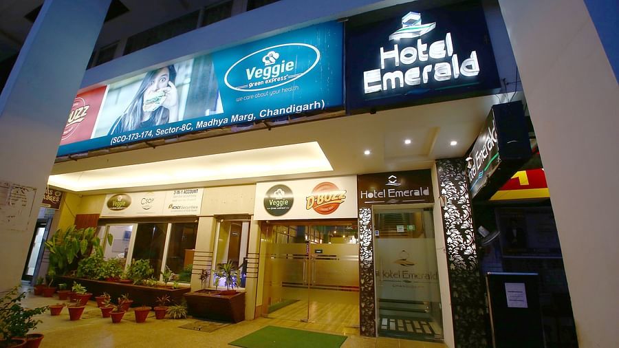 The exterior view of Hotel Emerald at night, with bright signage and an inviting entrance - Hotel Emerald, Chandigarh
