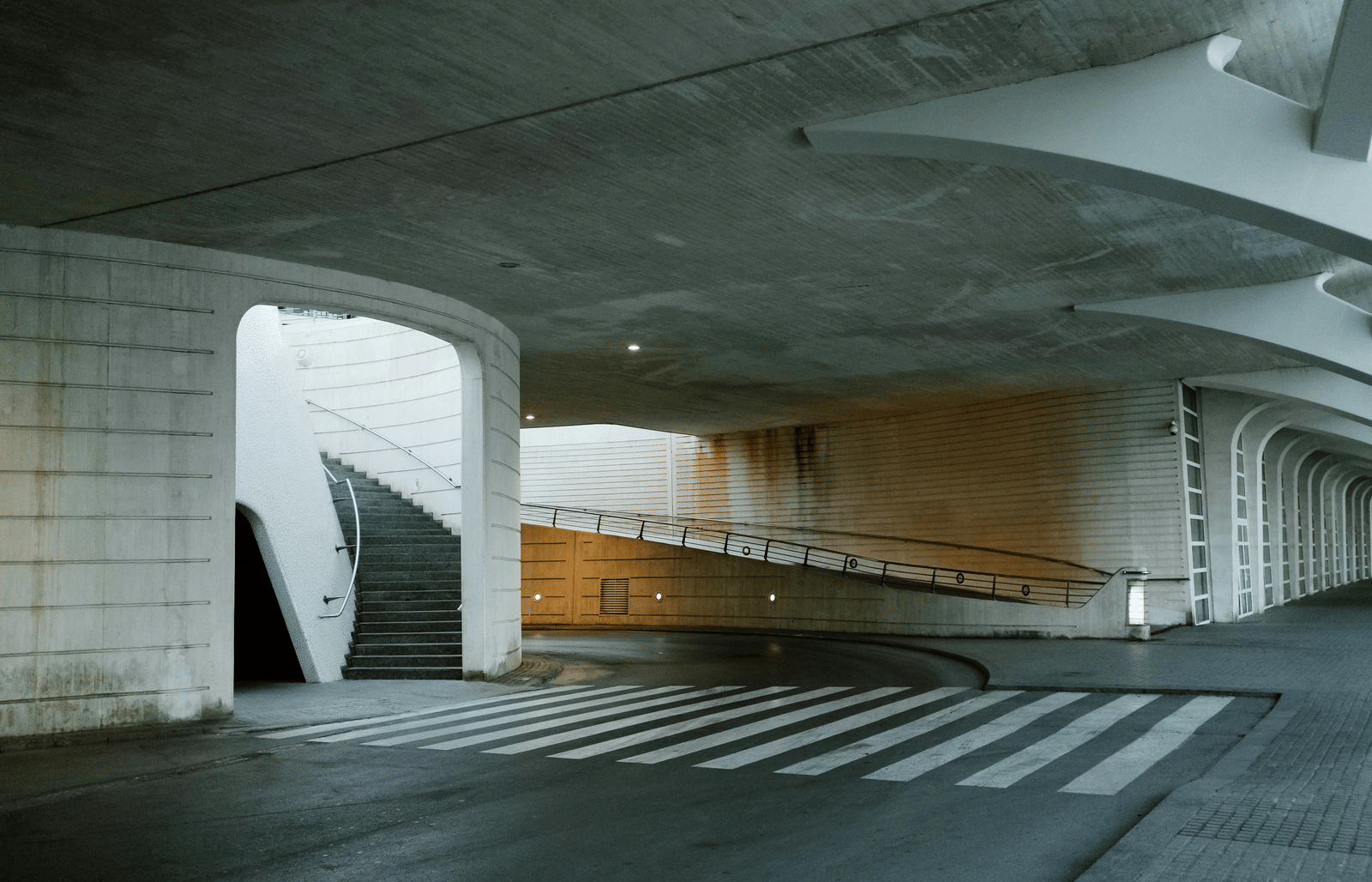 An image of a parking area showcasing a staircase, and zebra crossing