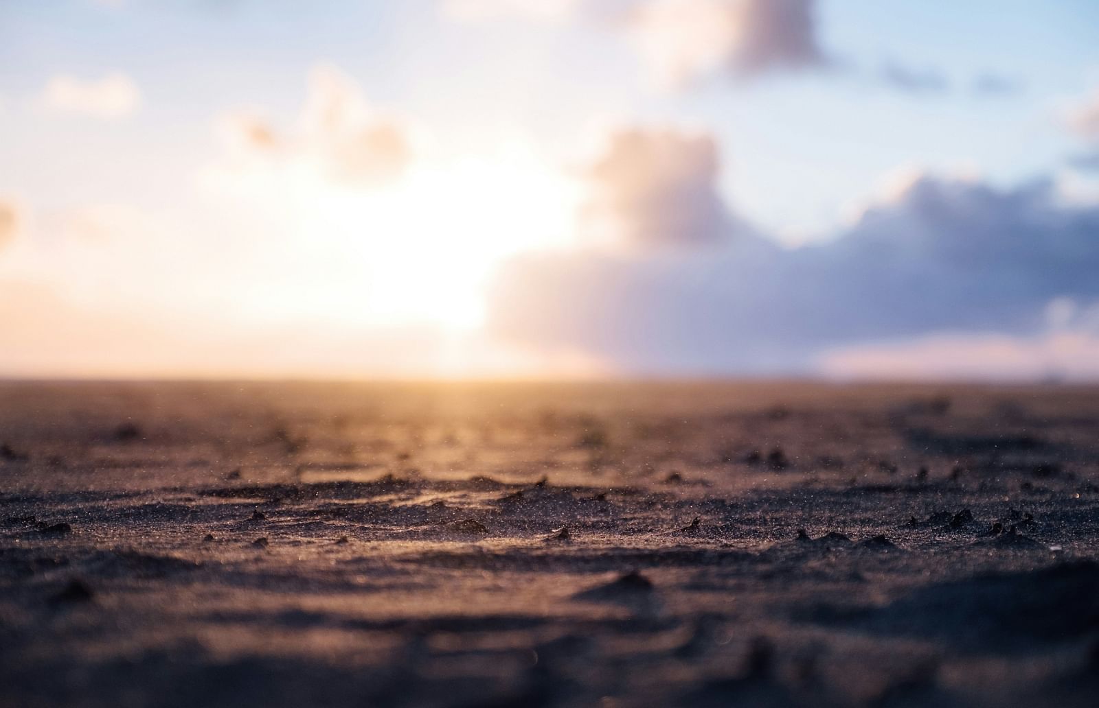 An overview of a waterbody with water droplets falling on it and the sun in the background