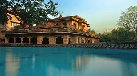 A facade image of Sukhdham Kothi seen from the side of a pool
