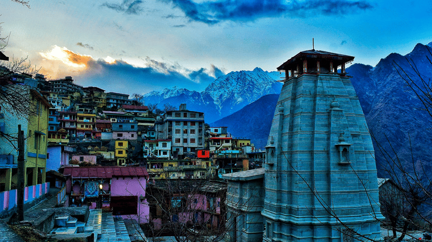 image featuring the top portion of a temple with the landscape of a city with small houses