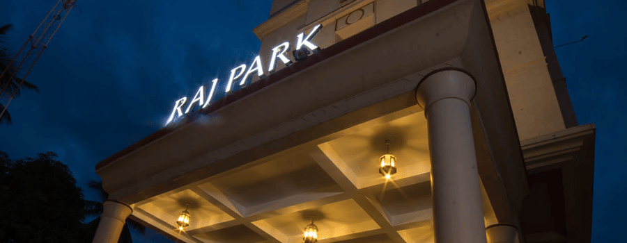 Facade of Hotel raj Park, chennai with dark sky in the backdrop.