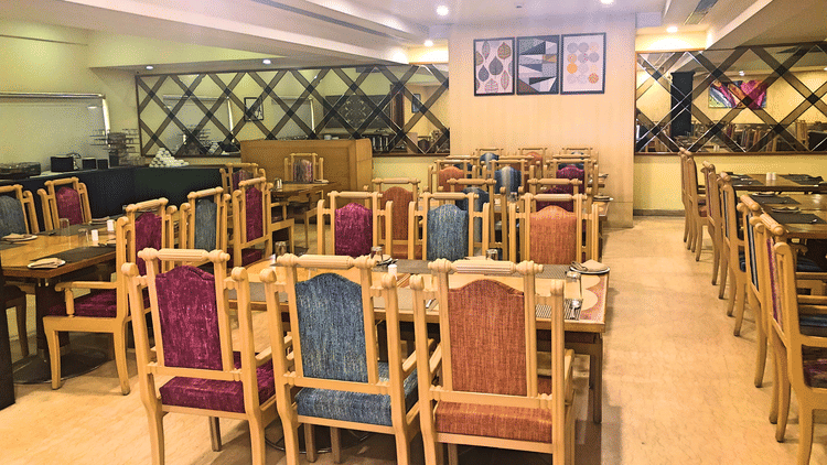 seating arrangments inside a restaurant with the lights switched on - Raj Park Hotel, Tirupati