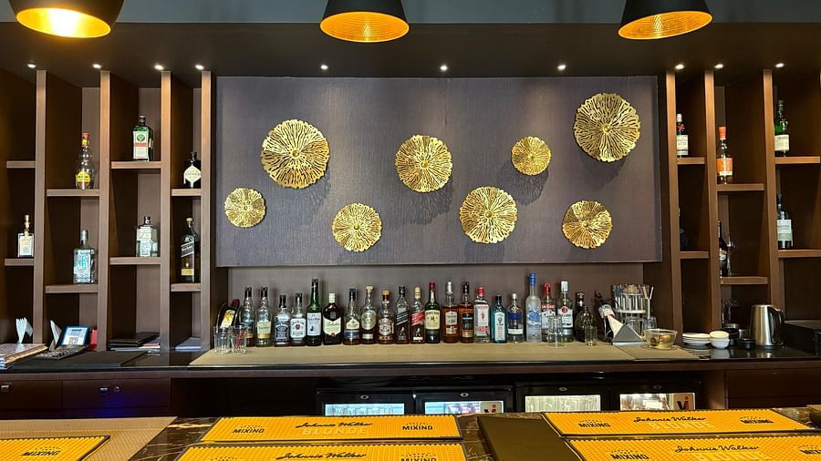 A bar counter with menus and a decorative back wall featuring gold accents, emphasizing the bar's offerings and design.
