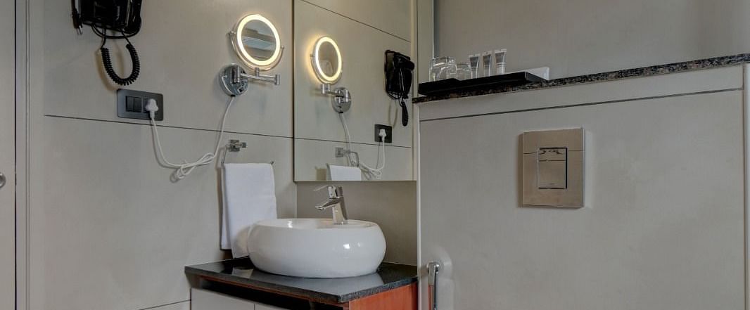 Image of a washroom with a sink and a toilet beside it at Hari Govindas, Siddappa Square.