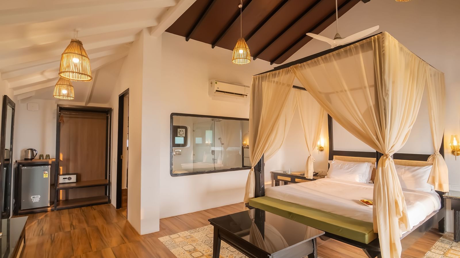 A crafted bedroom with a bedding having cosy mattress, curtains and fancy lightings, with a see through washroom - Crescent Resorts