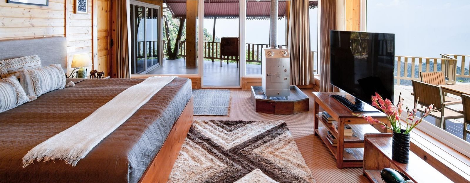 An image of full view of the room with a bed tv heater and patio | Avalon Cottages, Kanatal