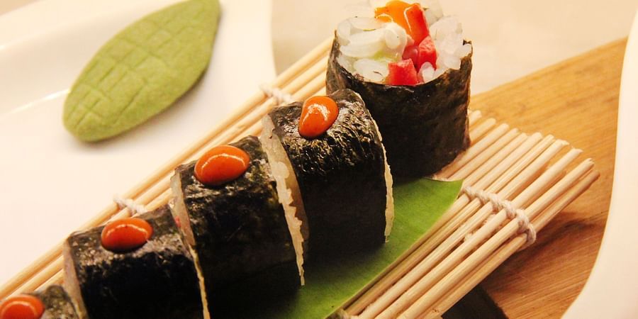 Assorted sushi elegantly presented on a bamboo plate.
