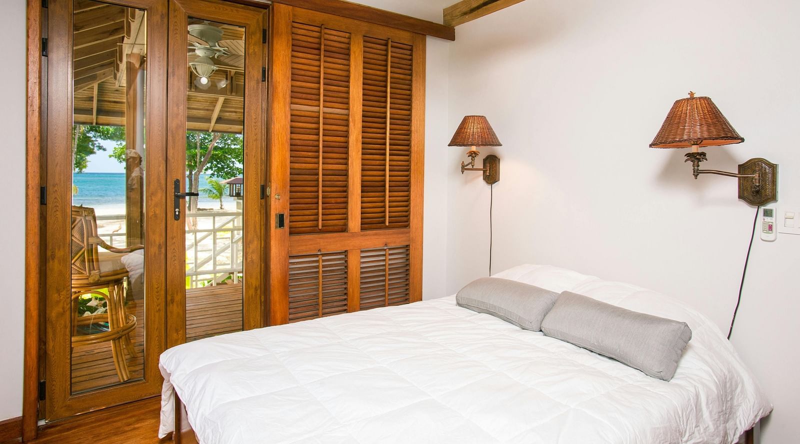 A bedroom with a king size bed with two lamps fixed to the wall