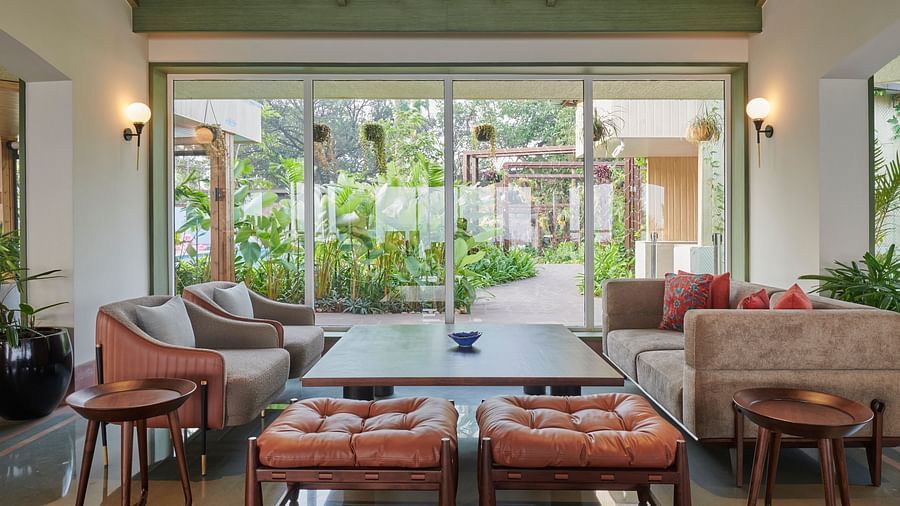 Bar seating area with stylish furniture, overlooking a lush garden view through large glass windows at The Dukes Retreat