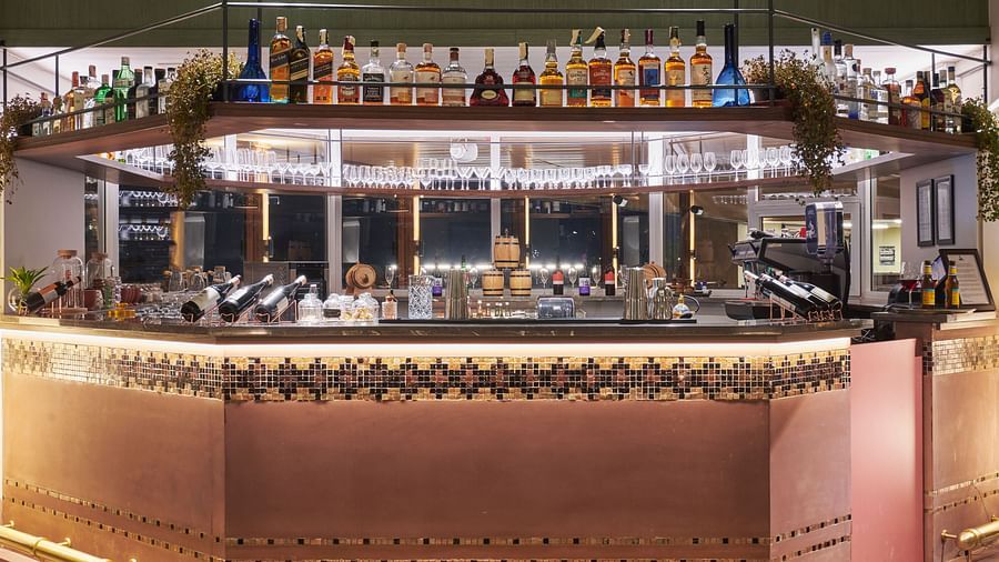 Illuminated bar counter showcasing a variety of bottles with stylish lighting at The Dukes Retreat
