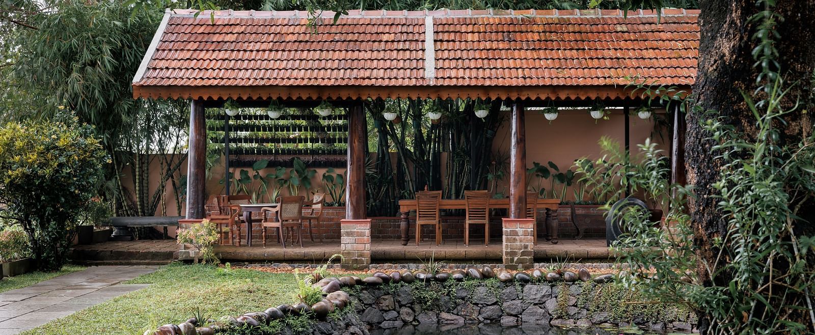 A facade image showcasing the pond at BluSalzz Villas - Muhamma Resort, Alleppey and the outdoor seating area of the restaurant