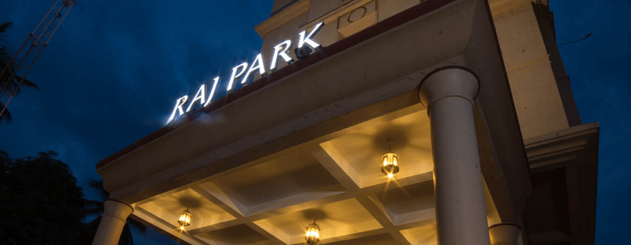 Facade of Hotel raj Park, chennai with dark sky in the backdrop.