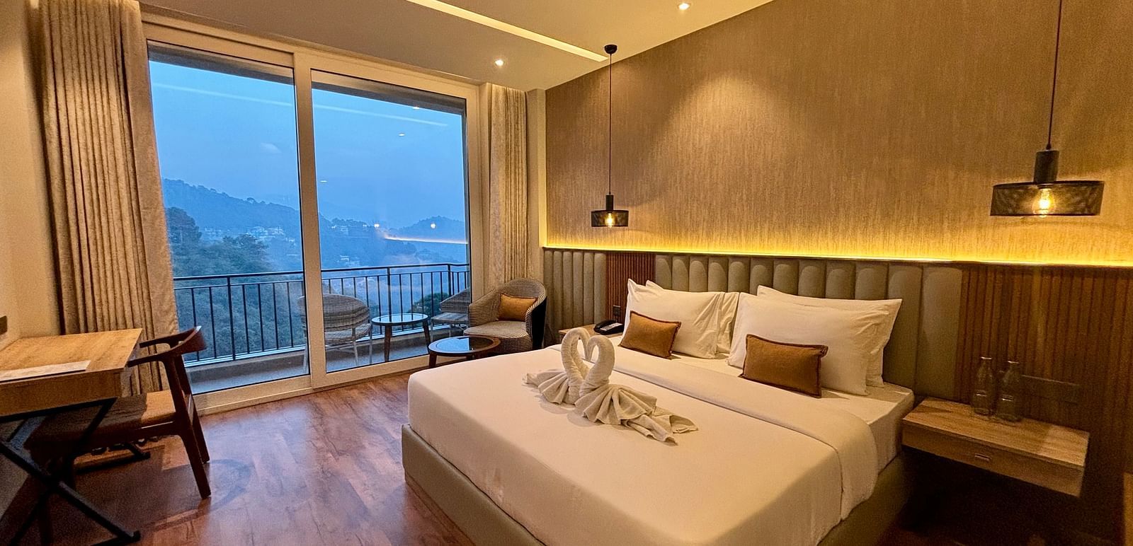 Elegant bedroom with large windows, wooden accents, and a scenic balcony view – ARNISA Boutique Hotel