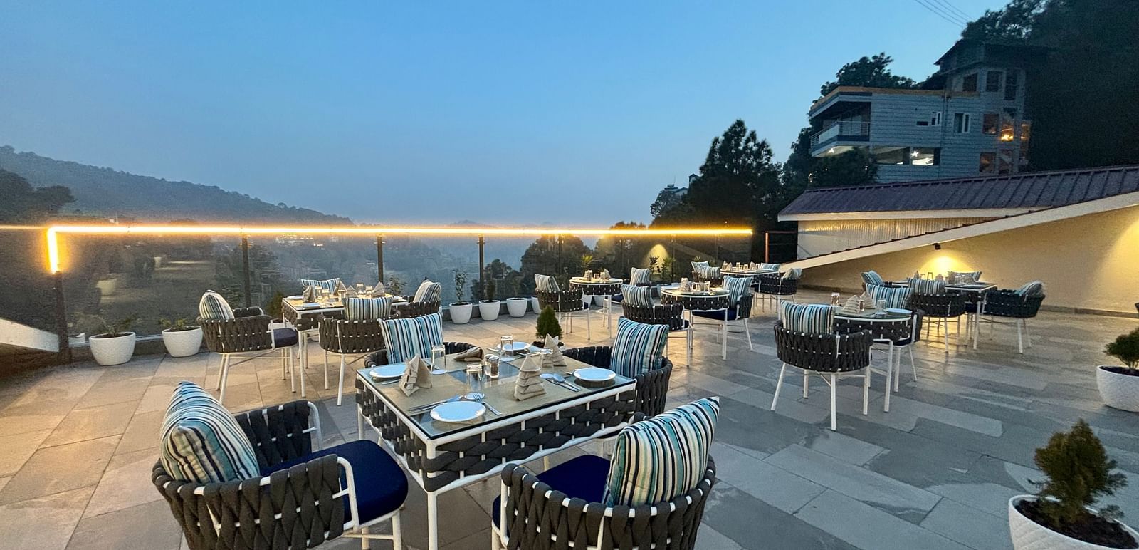 Outdoor dining area at twilight with neatly arranged tables and scenic views – ARNISA Boutique Hotel