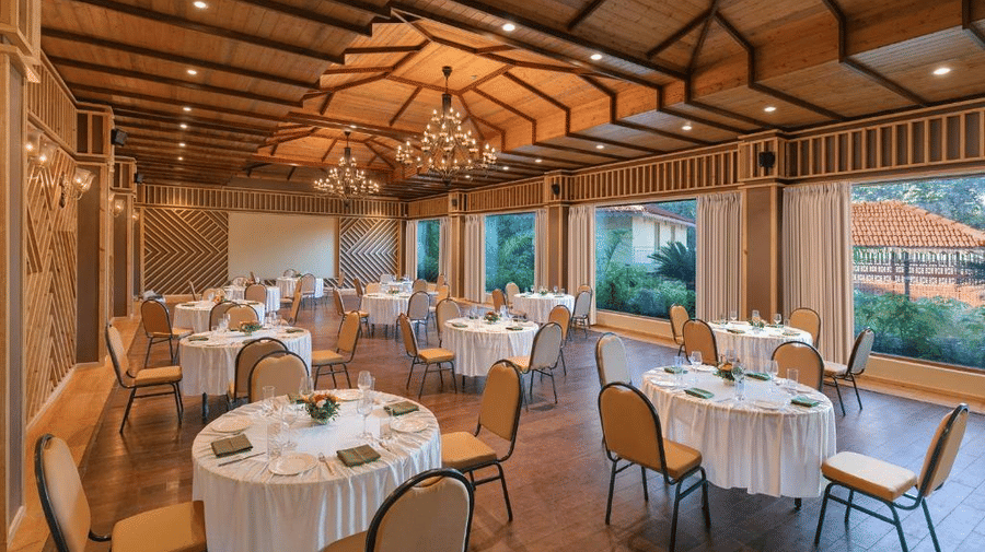 A wide-angle shot of The Grandeur banquet hall in Goa featuring the tables and chairs nicely arranged in cluster setting configuration - Golden Tulip Goa Mandrem