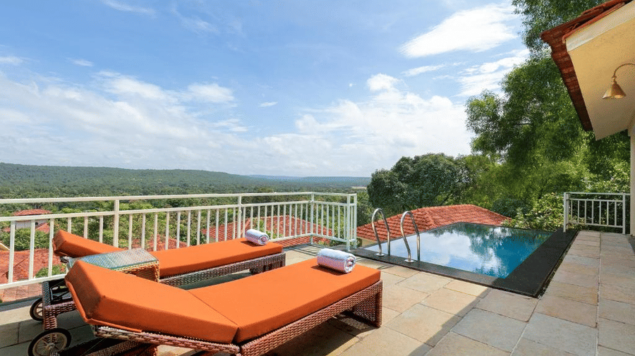 The expansive balcony of the Presidential Suite featuring 2 sun loungers kept by the infinity pool during the afternoon - Golden Tulip Goa Mandrem