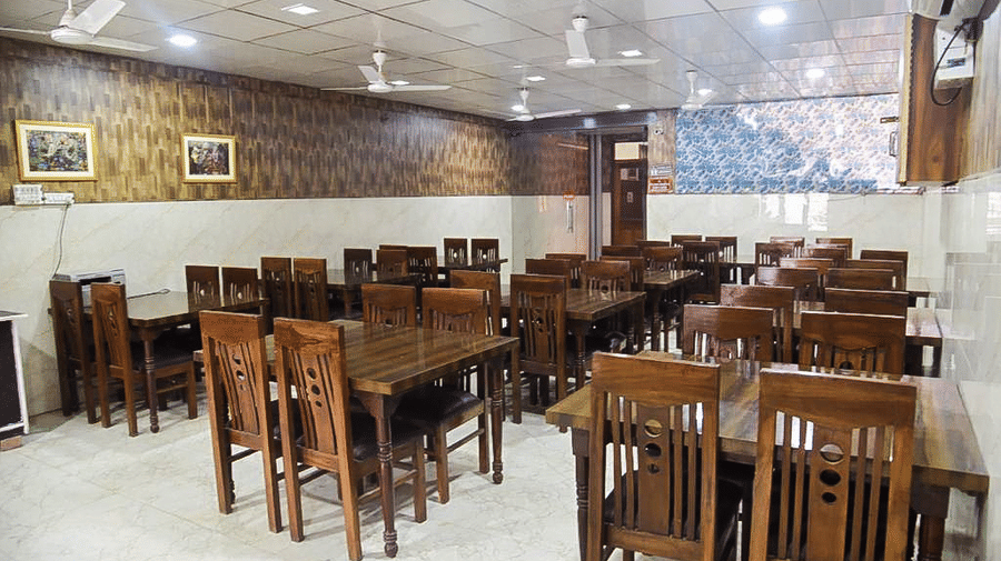 The dining area with the chairs and tables arranged - Hotel Goverdhan, Agra