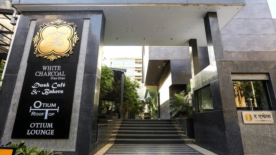 Grand building entrance featuring dark granite columns, steps leading up, and black signage plaques on the side.