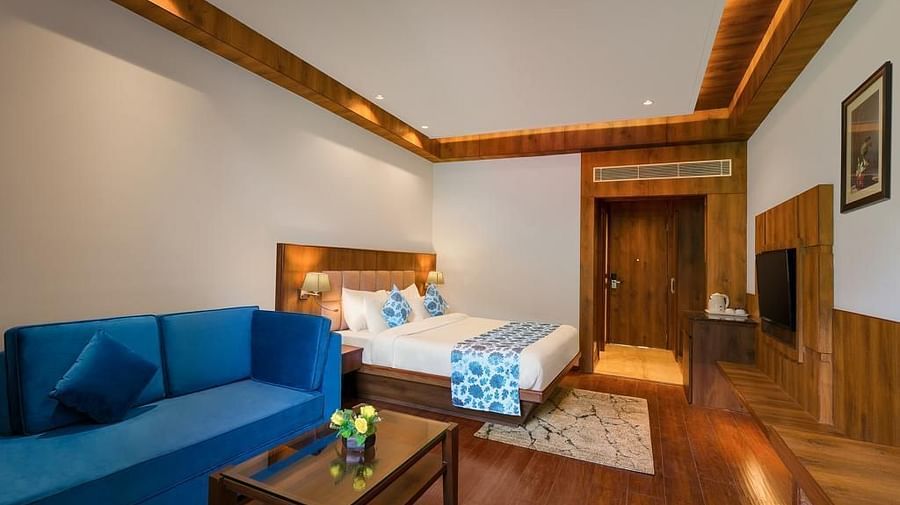 Room with a comfy bed and cushy sofa at The Orchid Hotel in Manali