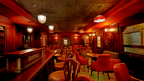 Moon and Sixpence at Hablis Hotel, one of the best Hotels near Phoenix Market City, Chennai, featuring vintage-style interior with warm lighting, wooden furniture and red upholstered chairs