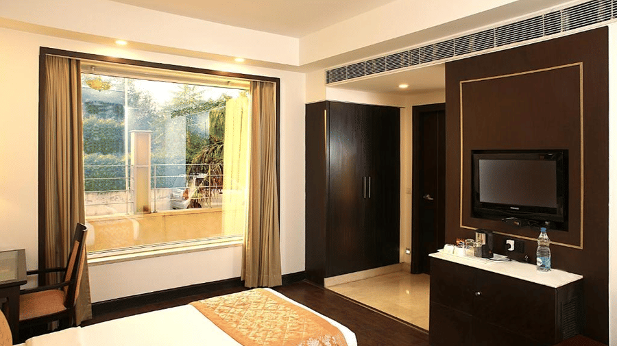 A large window brightens a room featuring dark cabinetry and a wall-mounted TV at Eastlynn Collections Huda City Centre.