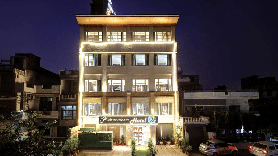 The hotel facade illuminated at night with warm decorative lighting highlighting the windows and the entrance area - Flute Boutique By Hotel 91, Jaipur